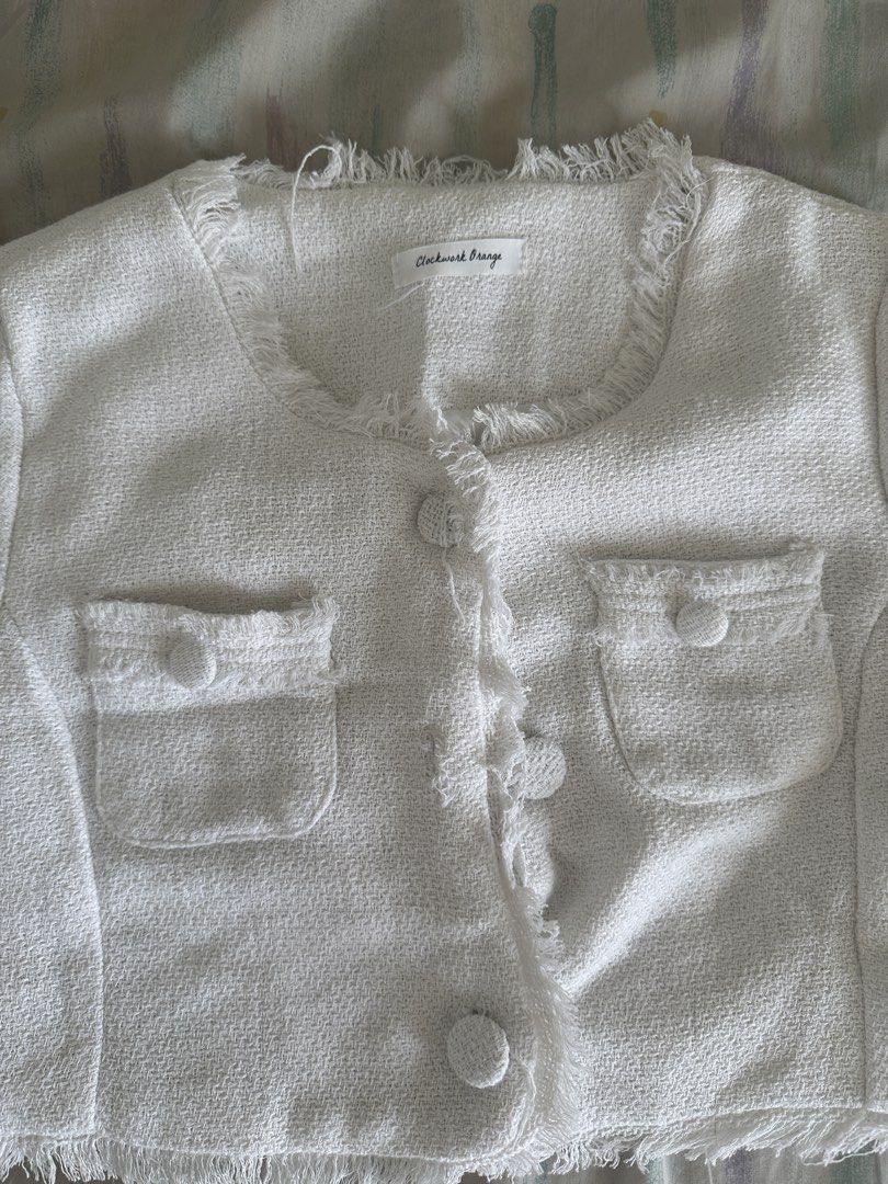 White Cropped Tweed Jacket with Fringed Trim (Category: Coats, Jackets and Outerwear) located in Paranaque City. Submitted by declutterwyae (Listing ID 1440437482, Image 2). Description: - White cropped jacket - Textured tweed fabric - Short sleeves with fringed cuffs - Fringed hemline and neckline - Button-up front with two chest pockets - Estimated size: Small - Perfect for dressing up or down.