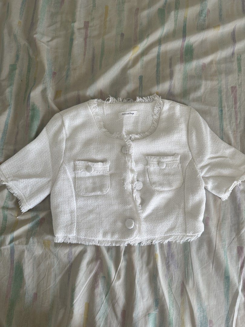 White Cropped Tweed Jacket with Fringed Trim (Category: Coats, Jackets and Outerwear) located in Paranaque City. Submitted by declutterwyae (Listing ID 1440437482, Image 1). Description: - White cropped jacket - Textured tweed fabric - Short sleeves with fringed cuffs - Fringed hemline and neckline - Button-up front with two chest pockets - Estimated size: Small - Perfect for dressing up or down.