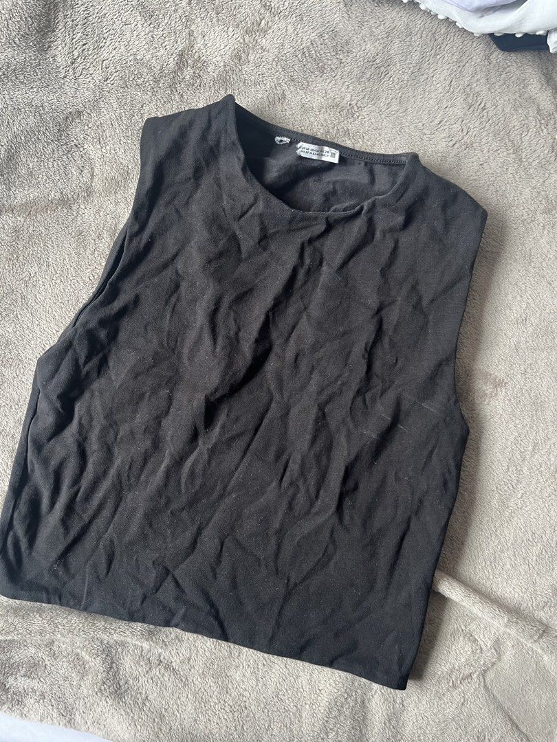 Zara Black Sleeveless Muscle Tee (Category: Sleeveless) located in Quezon City. Submitted by giaaaaa123 (Listing ID 1440550455, Image 1). Description: - Black sleeveless top from Zara - Features shoulder pads for a structured look - Simple and versatile design - Perfect for layering or wearing solo - Effortlessly pairs with any outfit - Ideal for casual occasions.