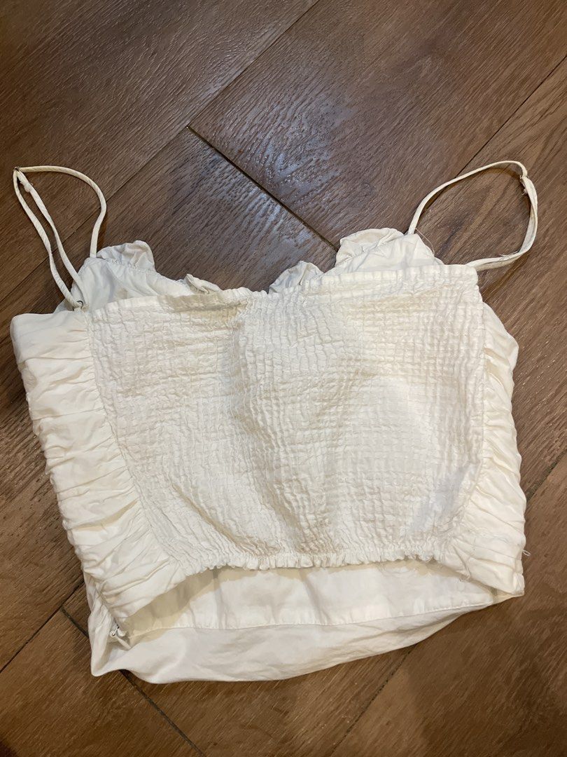 Zara White Smocked Ruffle Crop Top (Category: Sleeveless) located in Paranaque City. Submitted by TrendyBoutique.ph (Listing ID 1440528869, Image 2). Description: - White Zara crop top - Smocked bodice with ruffle trim - Adjustable spaghetti straps - Ruched detailing on the front - Versatile: pairs well with high-waisted jeans or skirts - Ideal for summer days and nights out.