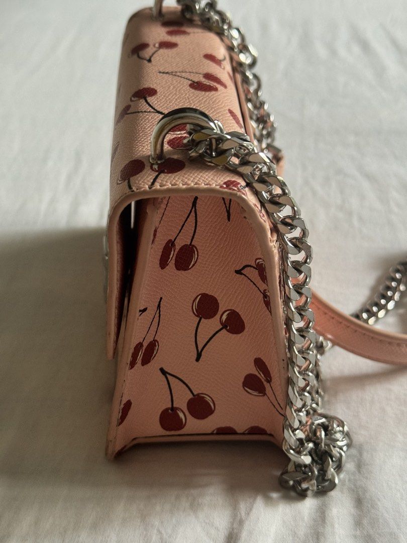 Benetton Pink Cherry Print Chain Shoulder Bag (Category: Shoulder Bags) located in Makati City. Submitted by blushvanilla (Listing ID 1440661009, Image 3). Description: - Adorable pink shoulder bag with a playful cherry print. - Features a stylish silver chain strap and clasp. - Interior is black with a small Benetton tag. - Perfect for adding a vibrant pop of color to any look. - Approximate measurements: 7 inches wide by 5 inches tall..