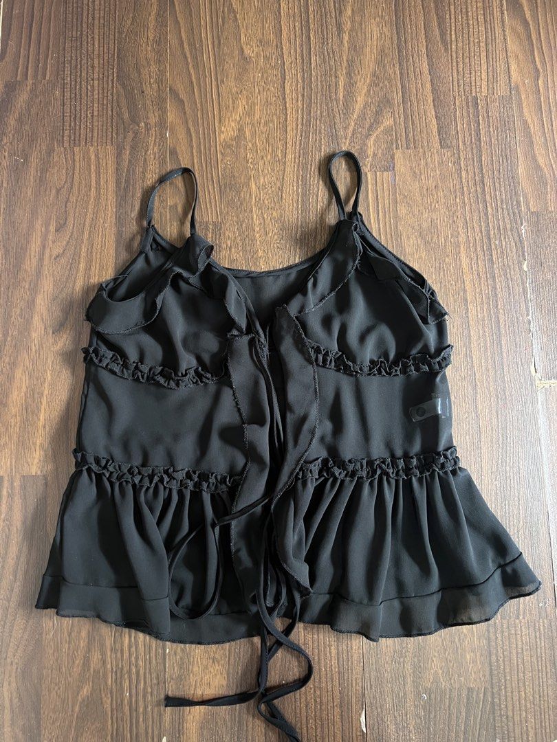 Black Ruffled Sheer Tie-Front Camisole Top (Category: Sleeveless) located in Antipolo. Submitted by riesns (Listing ID 1440658802, Image 1). Description: - Cute black camisole top - Features tie-front closure - Ruffled hem and neckline - Thin spaghetti straps - Made of flowy material - Ideal for layering or wearing on its own - Easy to style up or down.