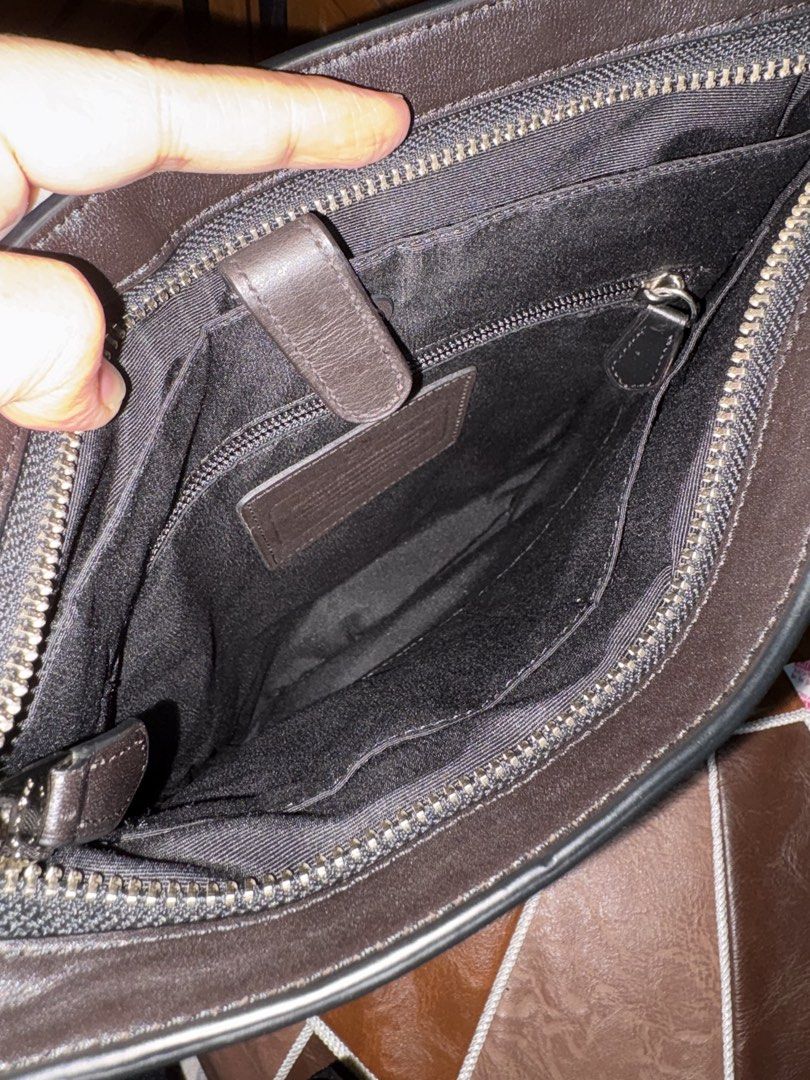 Coach Signature Monogram Crossbody Bag (Category: Sling Bags) located in Paranaque City. Submitted by jnetpreloveditems (Listing ID 1440653913, Image 2). Description: - Coach crossbody bag - Signature monogram print - Dark brown and black colorway - Genuine leather trim and strap - Secure zipper closure - Multiple interior compartments for organization - Ideal for everyday use, fits phone, wallet, keys, and other essentials.