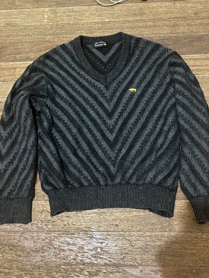 Dark Grey Chevron Knit Sweater (Category: Coats, Jackets and Outerwear) located in Taguig. Submitted by yvezntually (Listing ID 1440743280, Image 2). Description: - Cool dark grey sweater - Stylish chevron pattern - V-neck design - Long sleeves with ribbed cuffs - Ribbed hem - Small embroidered logo on chest - Versatile for layering or standalone wear.