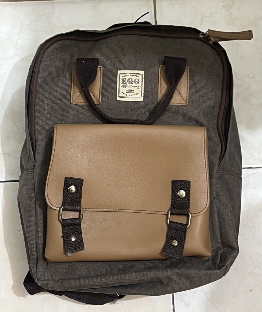 EGG Marcus Backpack (Category: Backpacks) located in Malabon City. Submitted by rika_26 (Listing ID 1440615409, Image 1). Description: Color: Dark gray with beige/tan accents > Canvas-like material with leather-style front pocket > Adjustable straps and sturdy handles RFS: Decluttering .