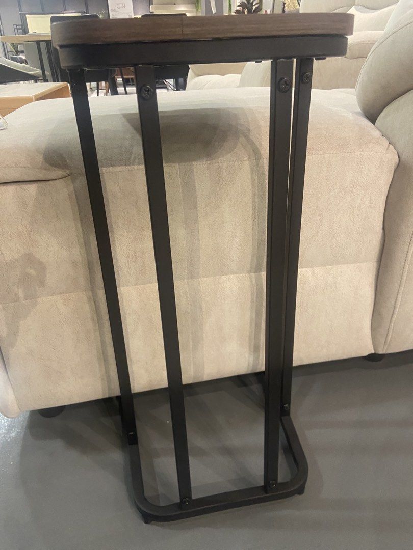 End table (Category: Tables & Sets) located in Kuala Lumpur. Submitted by nomadxstore (Listing ID 1440653574, Image 3). Description: - Convenient C-shaped design - Wood-look top with rounded edges - Sturdy black metal frame - Slides easily under sofas/chairs - Ideal for snacks, drinks, or laptops - Compact and functional for small spaces.