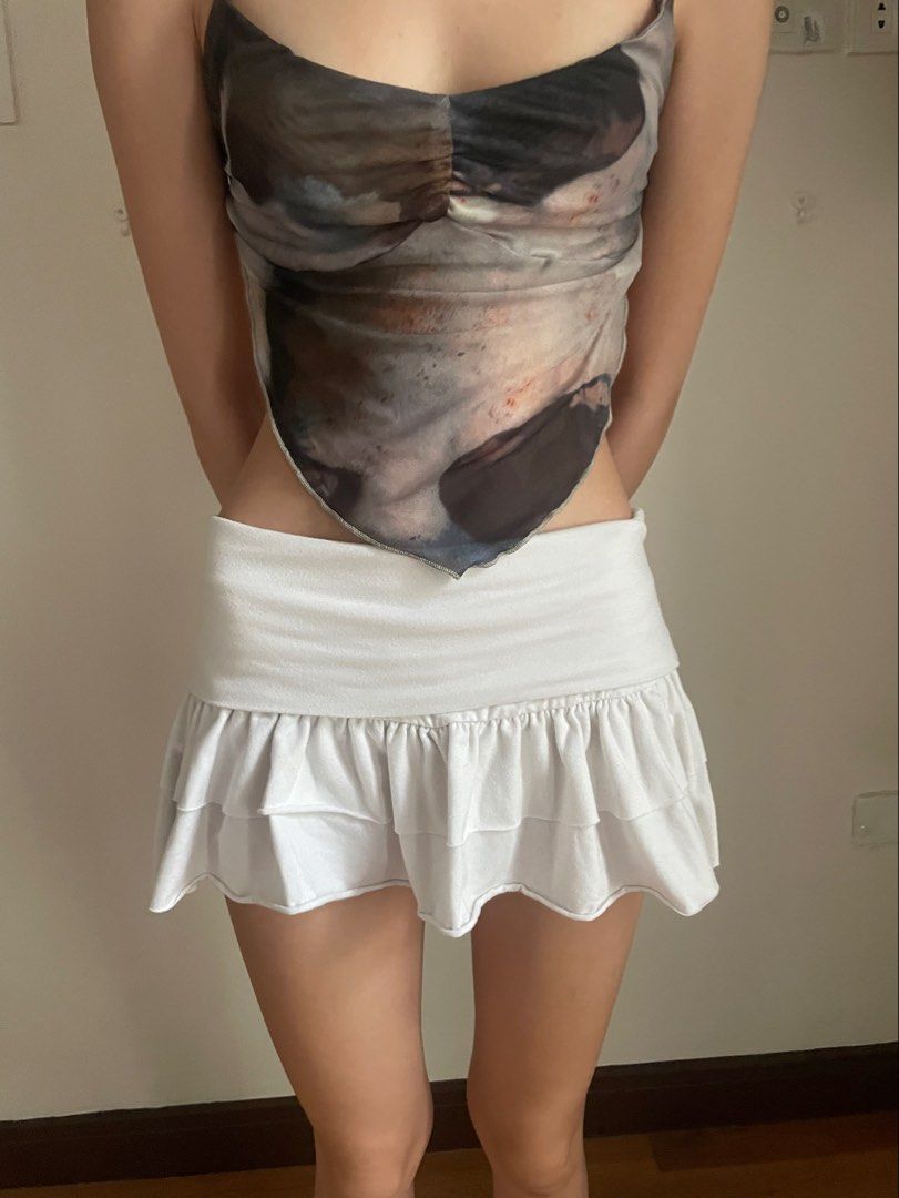 Folded white mini skirt with built in shorts (Category: Skirts) located in Binan City. Submitted by missing1naction (Listing ID 1440674934, Image 1). Description: No flaws in good condition Model measurements 5’3ft Waist 22in Hips 28in .