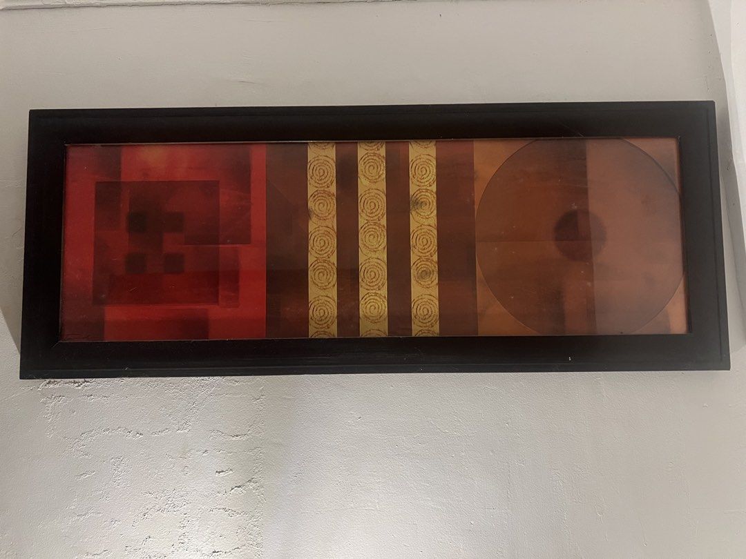 Framed Abstract Wall Art - Modern Decor (Category: Wall Decor) located in Caloocan City. Submitted by kcconstntino (Listing ID 1440689331, Image 1). Description: - Long, narrow framed art piece - Features abstract geometric shapes and lines - Warm color palette: red, orange, brown - Accented with gold spiral details - Sleek black frame - Perfect for a modern aesthetic - Ready to hang.