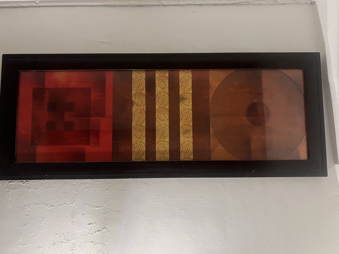 Framed Abstract Wall Art - Modern Decor (Category: Wall Decor) located in Caloocan City. Submitted by kcconstntino (Listing ID 1440689331, Image 2). Description: - Long, narrow framed art piece - Features abstract geometric shapes and lines - Warm color palette: red, orange, brown - Accented with gold spiral details - Sleek black frame - Perfect for a modern aesthetic - Ready to hang.