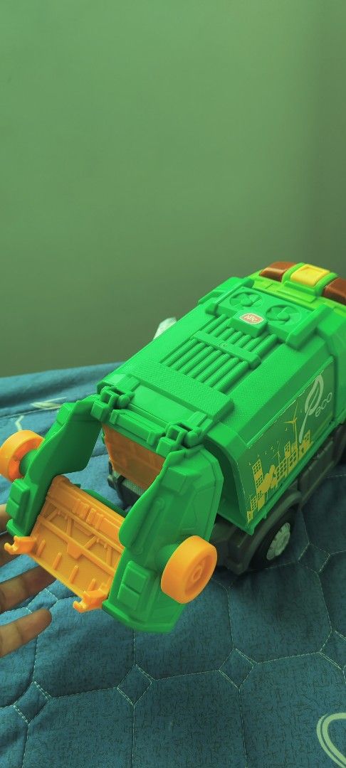 Green Eco Garbage Truck Toy (Category: Kids Toys) located in Taguig. Submitted by sgaur909 (Listing ID 1440585197, Image 3). Description: - Green toy garbage truck with 'eco' and leaf logo. - Features a city skyline and wind turbine graphic. - Back bin lifts up and detaches for interactive play. - Ideal for children interested in trucks and recycling. - Combines fun with educational value about environmentalism..