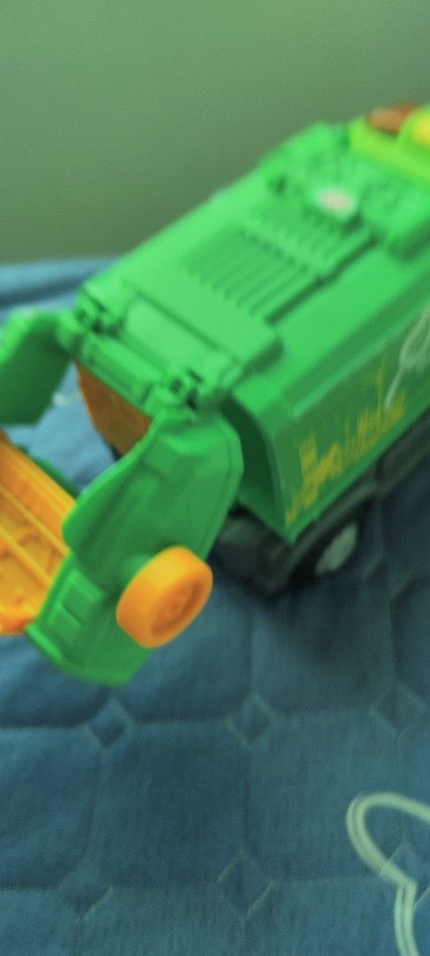 Green Eco Garbage Truck Toy (Category: Kids Toys) located in Taguig. Submitted by sgaur909 (Listing ID 1440585197, Image 2). Description: - Green toy garbage truck with 'eco' and leaf logo. - Features a city skyline and wind turbine graphic. - Back bin lifts up and detaches for interactive play. - Ideal for children interested in trucks and recycling. - Combines fun with educational value about environmentalism..