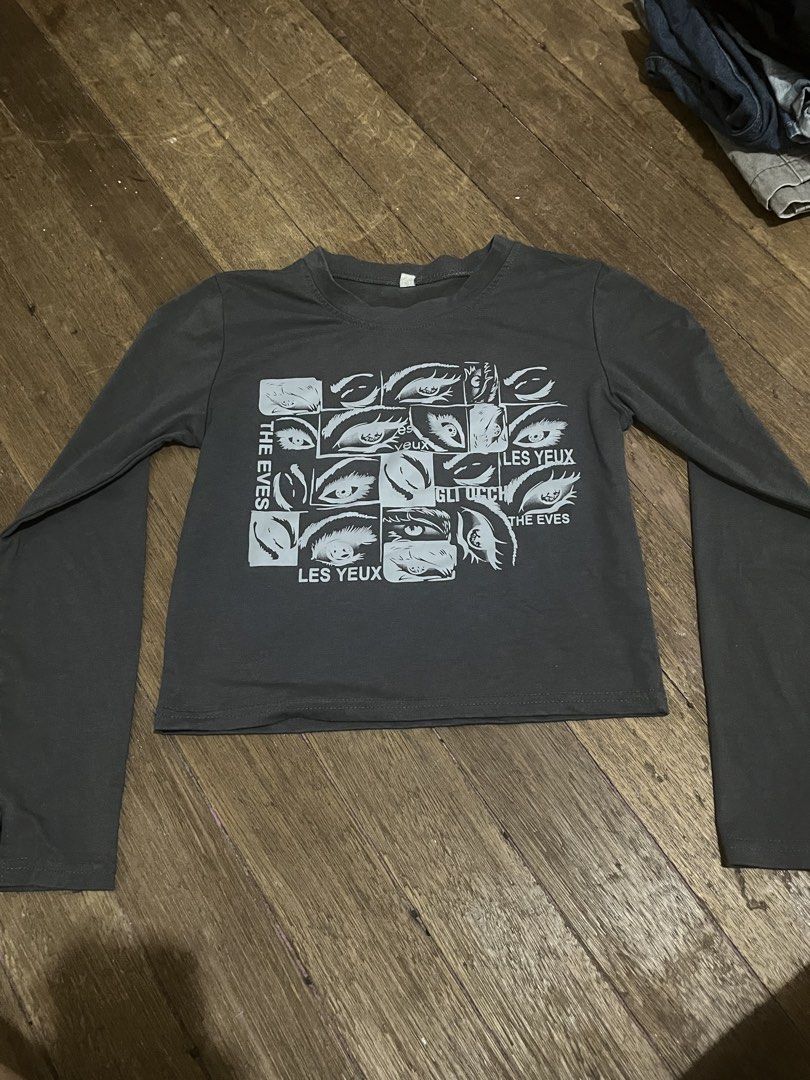 Grey Long Sleeve Crop Top with Eye Graphic (Category: Longsleeves) located in Taguig. Submitted by yvezntually (Listing ID 1440743027, Image 2). Description: - Grey long sleeve crop top - Features a graphic print of eyes and text - Flared sleeves - Estimated size: Small to Medium - Ideal for casual outfits.