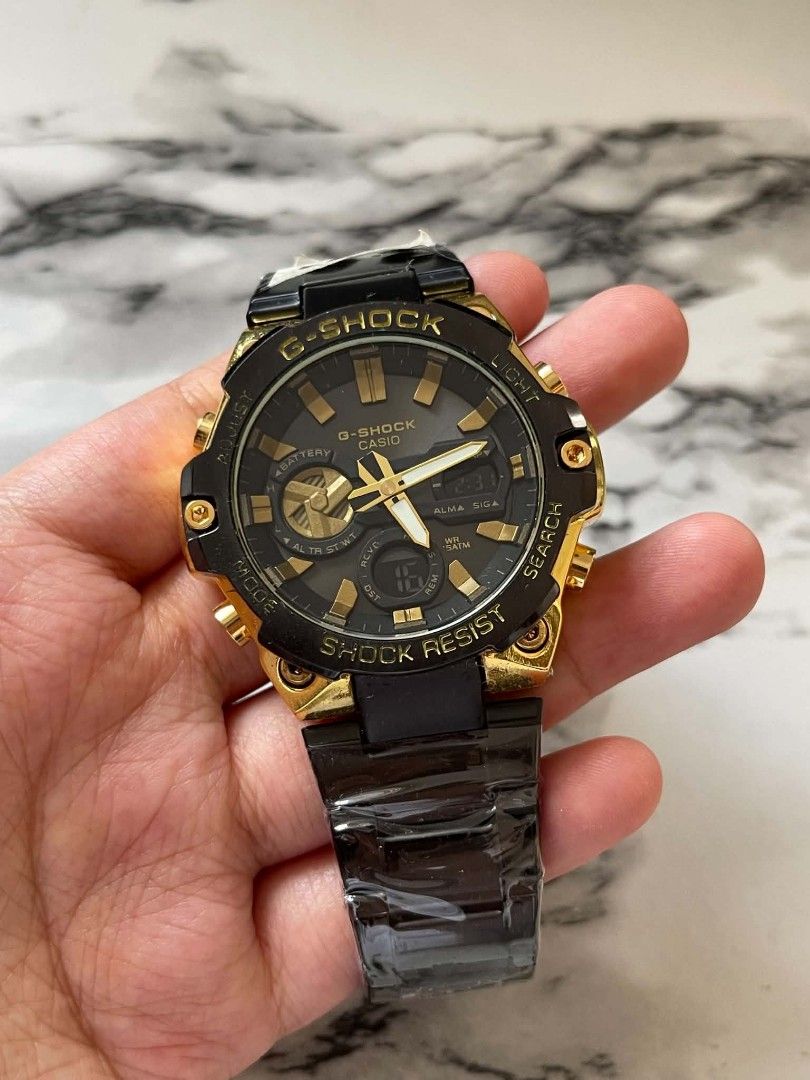G-Shock Casio Gold Black Shock Resist Watch MOD (Category: Men's Watches) located in Pasig City. Submitted by gheo0025 (Listing ID 1440725116, Image 3). Description: - G-Shock Watch - Gold and Black Accents - Shock Resist Feature - Analog Display with Digital Sub-dial - Metal Strap - Ideal for Everyday Wear or Sports - Selling with can and paper bag.