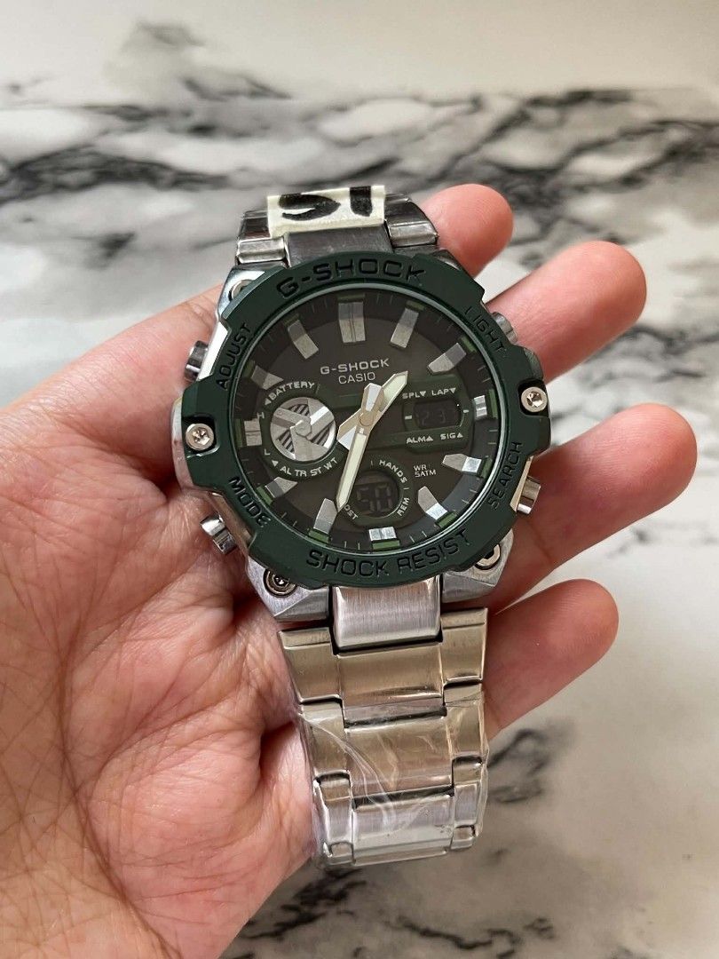 G-Shock Casio Watch MOD (Category: Men's Watches) located in Pasig City. Submitted by gheo0025 (Listing ID 1440725678, Image 3). Description: - G-Shock watch - Metal strap - Green bezel - Dark face - Analog and digital display - Shock resistant - Battery indicator visible - Some protective plastic still on strap with can and paper bag .