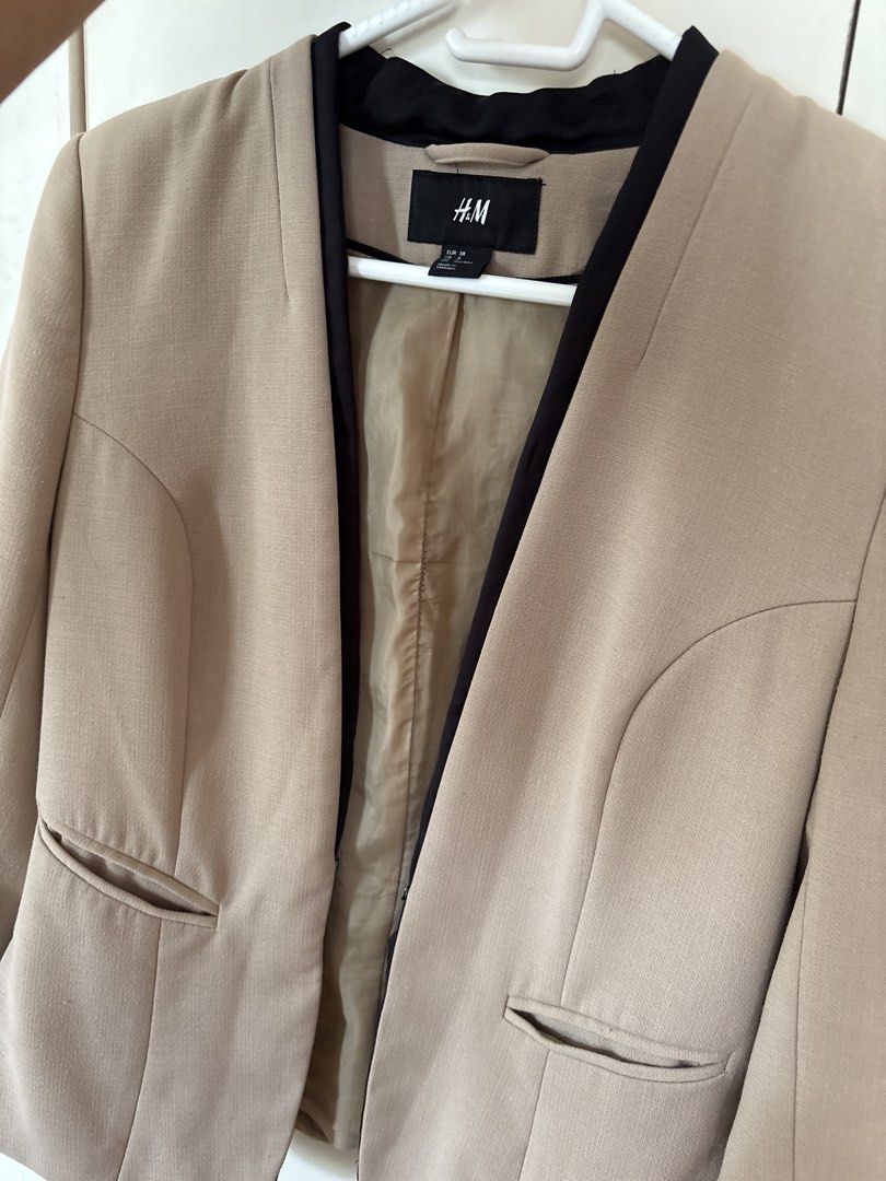 H&M Beige Collarless Blazer with Black Trim (Category: Coats, Jackets and Outerwear) located in Calamba. Submitted by reducereuserecycle. (Listing ID 1440614860, Image 1). Description: - Beige blazer from H&M - Collarless design with black trim - Two front pockets - Fully lined interior - Perfect for dressing up or down - Easy to pair with various outfits.