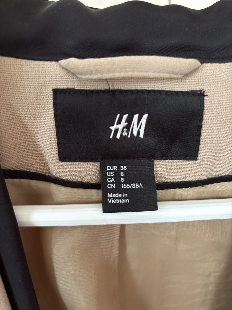 H&M Beige Collarless Blazer with Black Trim (Category: Coats, Jackets and Outerwear) located in Calamba. Submitted by reducereuserecycle. (Listing ID 1440614860, Image 2). Description: - Beige blazer from H&M - Collarless design with black trim - Two front pockets - Fully lined interior - Perfect for dressing up or down - Easy to pair with various outfits.