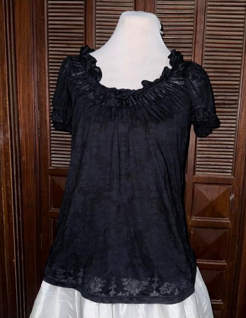 Juicy couture Whimsigoth Black Ruffled Blouse (Category: Blouses) located in Mandaue City. Submitted by element.fiona (Listing ID 1440601179, Image 1). Description: Good day, ladies! ✨ Details: Condition: Thrifted & pre-loved Color: Black Design: Ruffled scoop neckline, short puff sleeves, and a subtle floral damask pattern along the hem. Size: Small to Medium Style Tip: Perfect for whimsigoth, cottagecore, or grunge styles. Pair it with a white 
