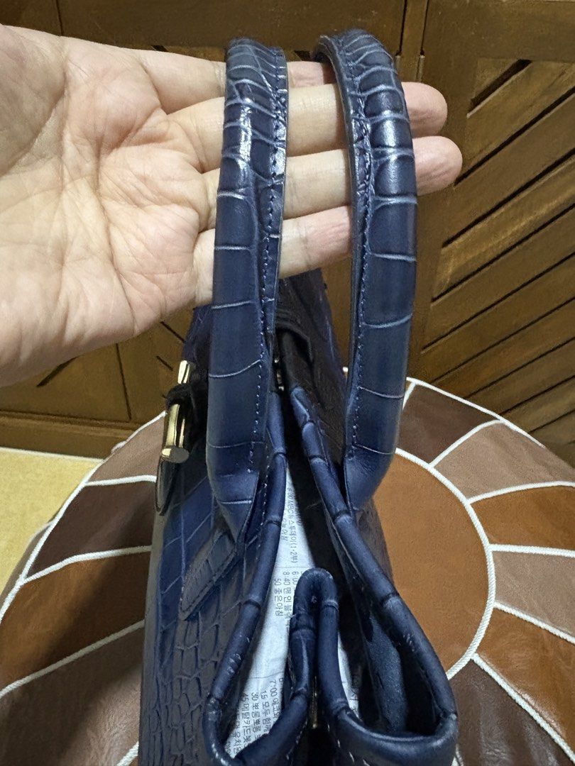 Longchamp Crocodile Embossed Leather Tote Bag Navy Blue (Category: Luxury Bags & Wallets) located in Paranaque City. Submitted by jnetpreloveditems (Listing ID 1440653702, Image 2). Description: - Navy blue Longchamp tote bag - Crocodile embossed leather exterior - Interior lining with butterfly print - Top handles for carrying - Front clasp closure - Spacious and versatile for everyday or special occasions.