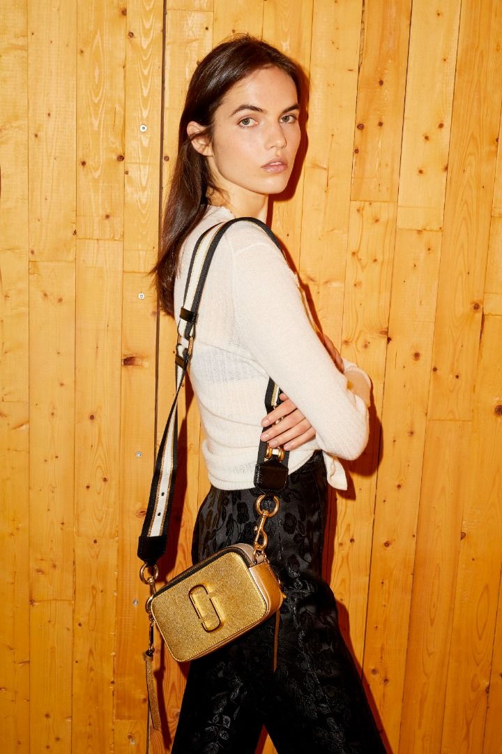 MARC JACOBS Snapshot Camera Bag METALLIC GOLD (Category: Luxury Bags & Wallets) located in Lucena. Submitted by brkrobert (Listing ID 1440582515, Image 1). Description: - Authentic Gold Marc Jacobs Snapshot camera bag - Features a detachable strap with black, white, and gold stripes - Strap is adorned with stylish metal stud details - All hardware is gold-tone - Shows some signs of wear on the hardware and strap, adding character.