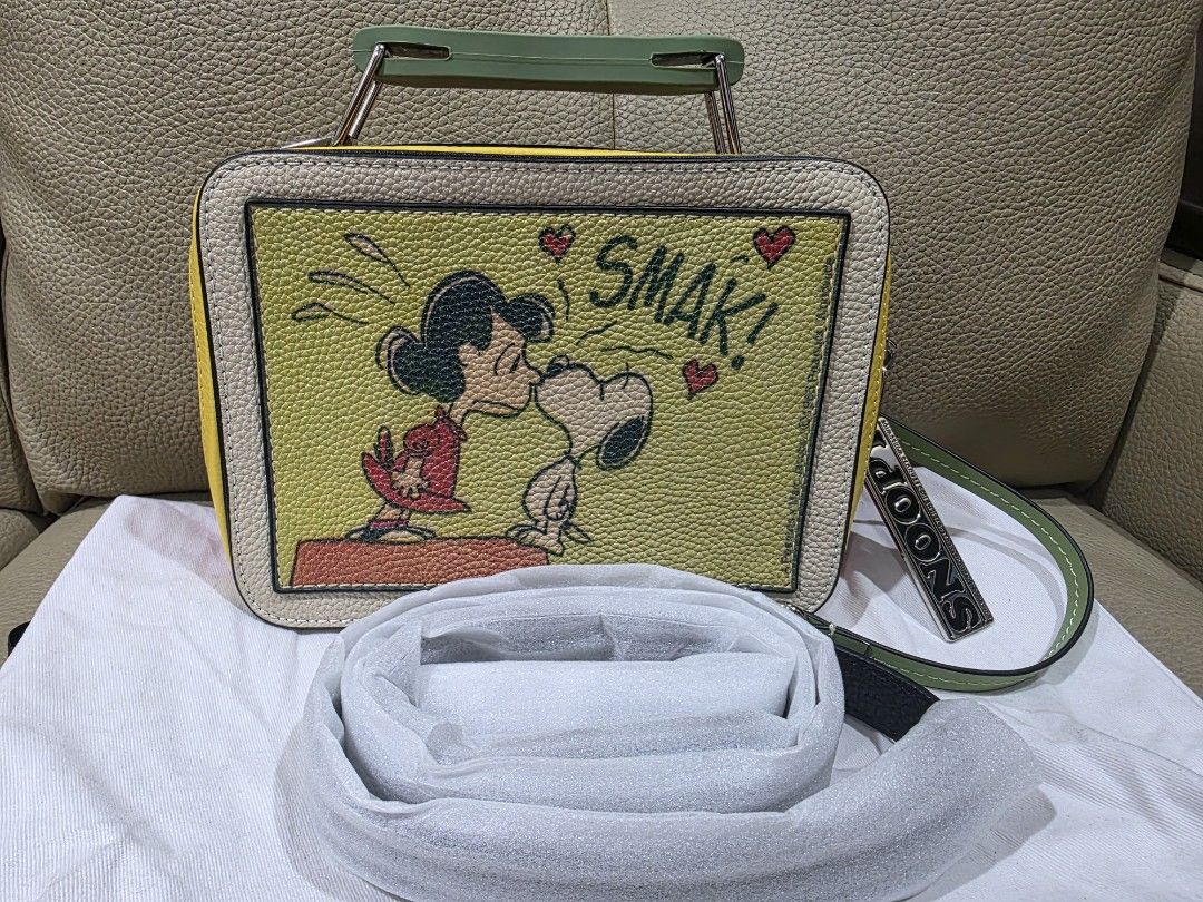 Marc Jacobs Snoopy Lunchbox Bag (Category: Luxury Bags & Wallets) located in Quezon City. Submitted by amcreationz.store (Listing ID 1440665734, Image 3). Description: - Authentic Marc Jacobs lunchbox bag - Adorable Snoopy and Woodstock print - Features Snoopy & Woodstock on one side - Lucy kissing Snoopy design on the other side - Includes a removable strap - Also has a top handle - Comes with a cute 'Snoopy' charm - A fun and unique statement p