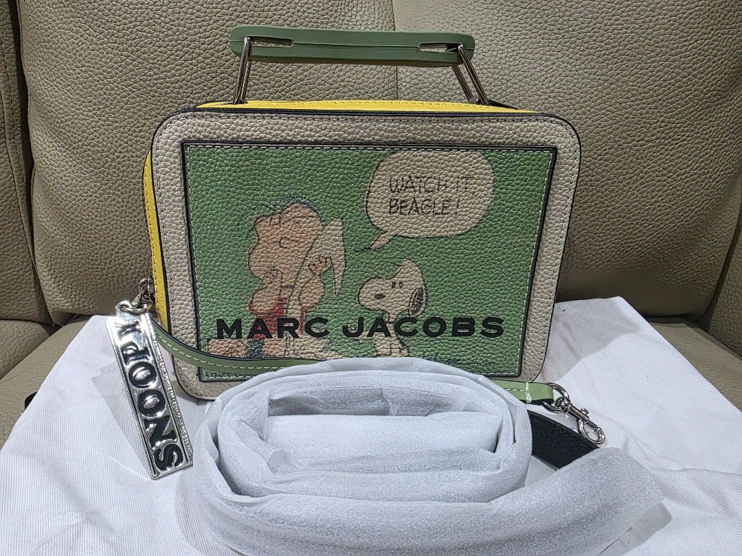 Marc Jacobs Snoopy Lunchbox Bag (Category: Luxury Bags & Wallets) located in Quezon City. Submitted by amcreationz.store (Listing ID 1440665734, Image 1). Description: - Authentic Marc Jacobs lunchbox bag - Adorable Snoopy and Woodstock print - Features Snoopy & Woodstock on one side - Lucy kissing Snoopy design on the other side - Includes a removable strap - Also has a top handle - Comes with a cute 'Snoopy' charm - A fun and unique statement p