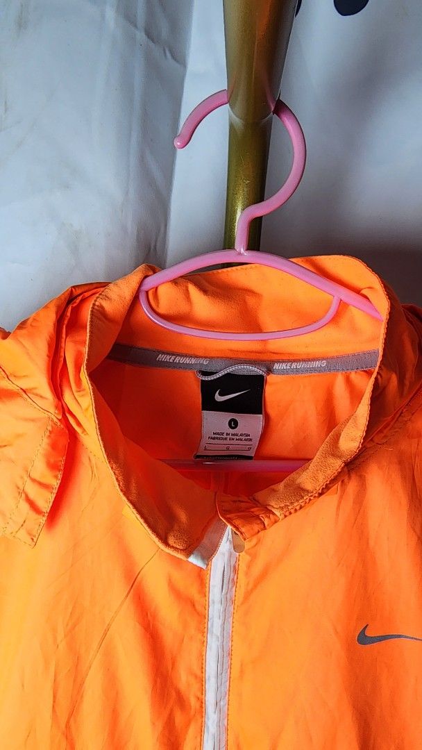 Nike Lightweight Running Jacket Orange White (Category: Coats, Jackets and Outerwear) located in Baguio. Submitted by chiechie1234 (Listing ID 1440591960, Image 2). Description: - Lightweight Nike running jacket - Full zip closure and two side pockets - Reflective details on sleeves for enhanced visibility - Breathable material with mesh sleeve lining - Ideal for running and casual wear.