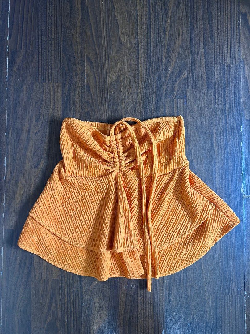 Orange Textured Ruched Top with Tie Detail (Category: Sleeveless) located in Antipolo. Submitted by riesns (Listing ID 1440658751, Image 1). Description: - Orange top with unique crinkled texture - Features ruched detail with a tie at the front - Estimated size: Small to Medium - Versatile for casual outings or as a beach cover-up.