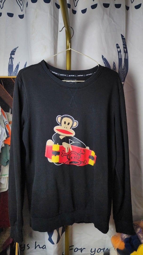 Paul Frank Black Monkey Skateboard Sweatshirt Size M (Category: Coats, Jackets and Outerwear) located in Baguio. Submitted by chiechie1234 (Listing ID 1440590329, Image 1). Description: - Brand: Paul Frank - Color: Black - Style: Long-sleeved sweatshirt - Size: Tagged M - Front Graphic: Iconic Julius monkey holding a skateboard - Back Graphic: Vertical stripes (yellow/red) with black lettering - Occasion: Casual wear.