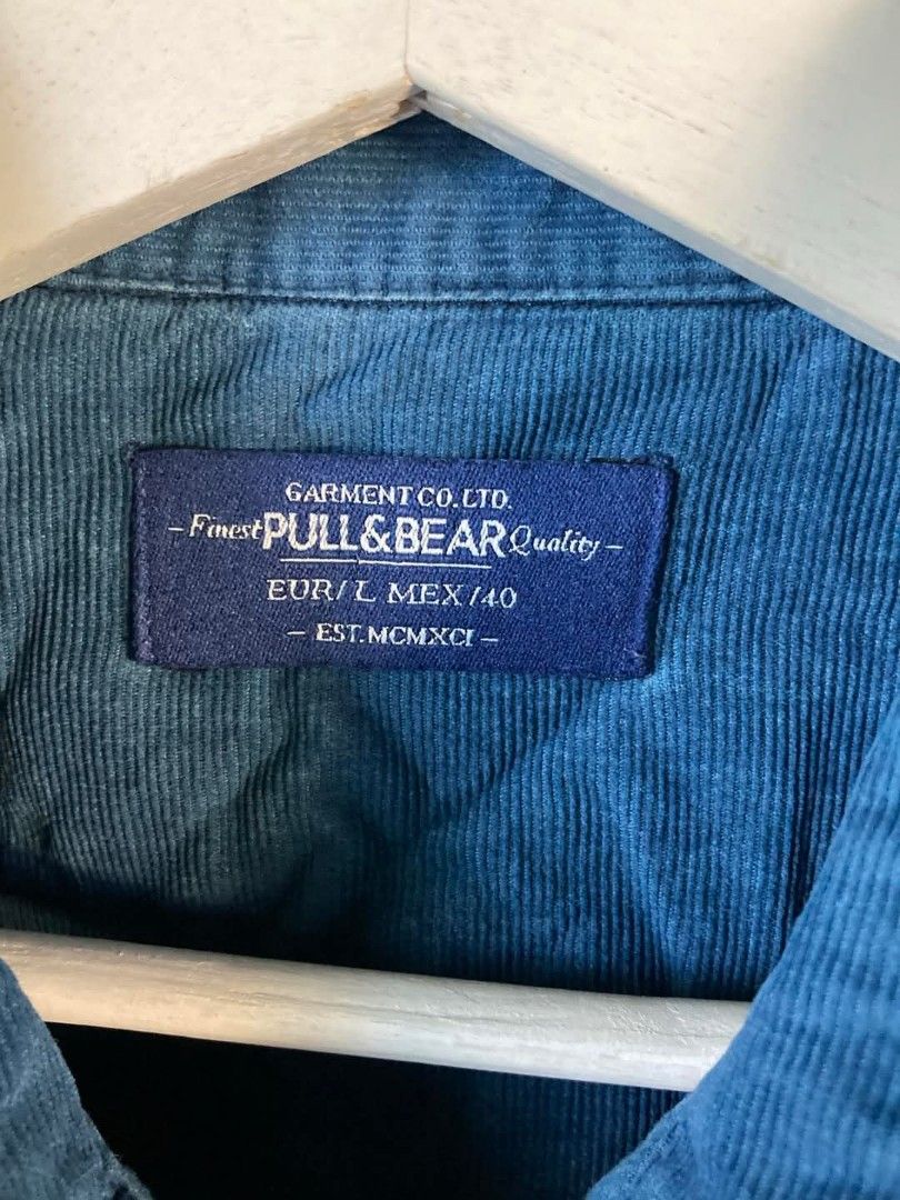 Pull & Bear Blue Corduroy Long Sleeve Shirt (Category: Tshirts & Polo Shirts ) located in Cavite. Submitted by eures_corner (Listing ID 1440609410, Image 2). Description: - Brand: Pull & Bear - Color: Blue - Material: Corduroy - Style: Long-sleeved denim shirt style - Features: Button cuffs, two chest pockets with button closures - Size: EUR L / MEX 40 - Occasion: Casual wear.