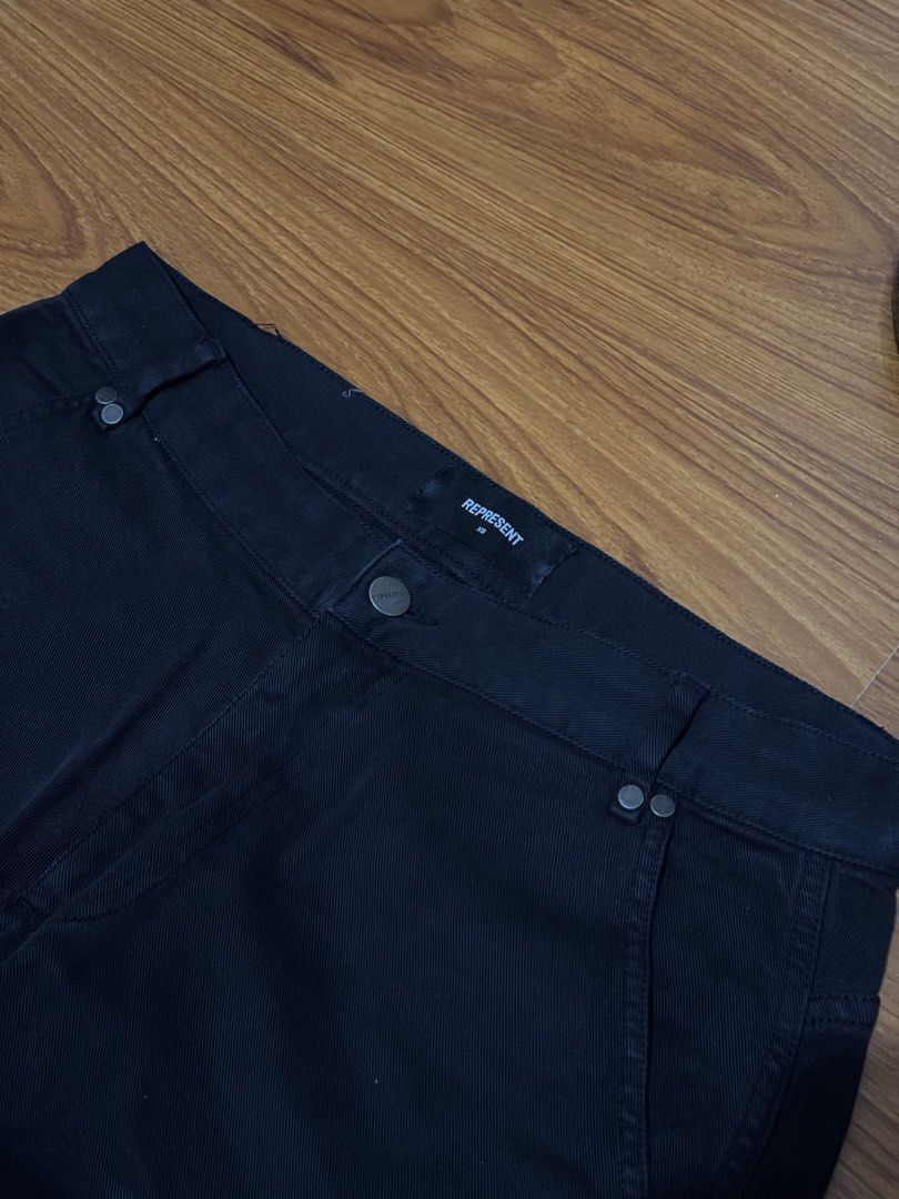 Represent Black Carpenter Pants (Category: Jeans) located in Bacoor. Submitted by hello.curated (Listing ID 1440606184, Image 2). Description: - Brand: Represent - Color: Black - Style: Cargo Pants - Size: Approx. 30 - Features: Multiple pockets, zip details - Closure: Button and zip fly - Ideal for: Everyday wear, streetwear looks.
