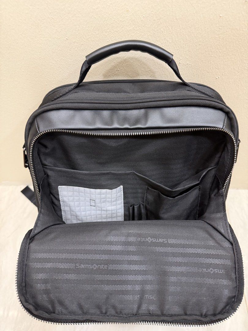 Samsonite Black Backpack with Multiple Compartments (Category: Backpacks) located in Singapore. Submitted by kiatz9 (Listing ID 1440715029, Image 2). Description: - Black Samsonite backpack - Ample storage with built-in organizers - Main compartment features zippered mesh and slip pockets - Front compartment with additional pockets for pens and small items - Padded back and shoulder straps for enhanced comfort - Perfect for work, school, or trave