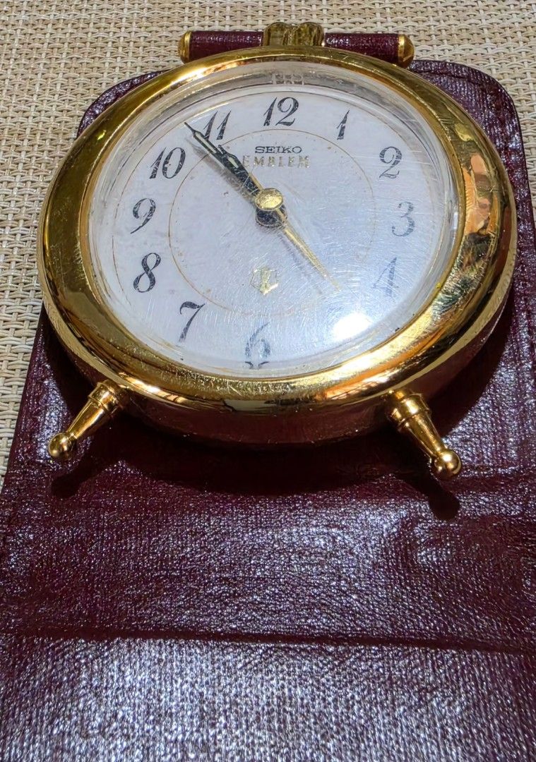 Seiko Emblem Gold Alarm Clock with Leather Case (Category: Clocks) located in Naga. Submitted by solamia (Listing ID 1440755068, Image 3). Description: - Vintage Seiko Emblem alarm clock - Gold tone casing with white face - Arabic numerals - Includes original burgundy leather travel case - Classic, timeless design - Ideal for desk or travel use.