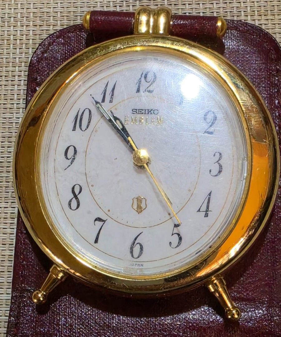 Seiko Emblem Gold Alarm Clock with Leather Case (Category: Clocks) located in Naga. Submitted by solamia (Listing ID 1440755068, Image 2). Description: - Vintage Seiko Emblem alarm clock - Gold tone casing with white face - Arabic numerals - Includes original burgundy leather travel case - Classic, timeless design - Ideal for desk or travel use.