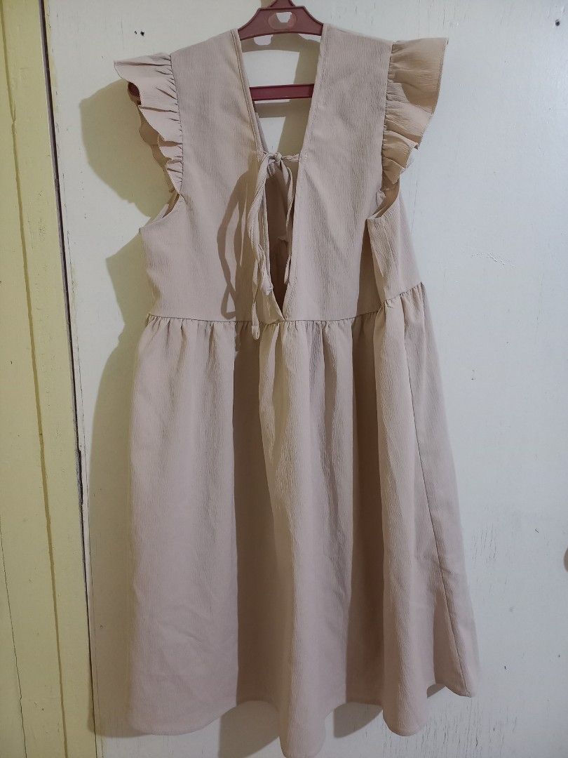 SHEIN Frenchy Solid Tie Back Smock Dress (Category: Dresses) located in Bulacan. Submitted by abscissa (Listing ID 1440685733, Image 3). Description: - Cute beige dress - Ruffle sleeves - V-neckline with criss-cross back detail - Elasticated waist - Flowy skirt - Ideal for casual outings - Easy to style with sandals or sneakers.