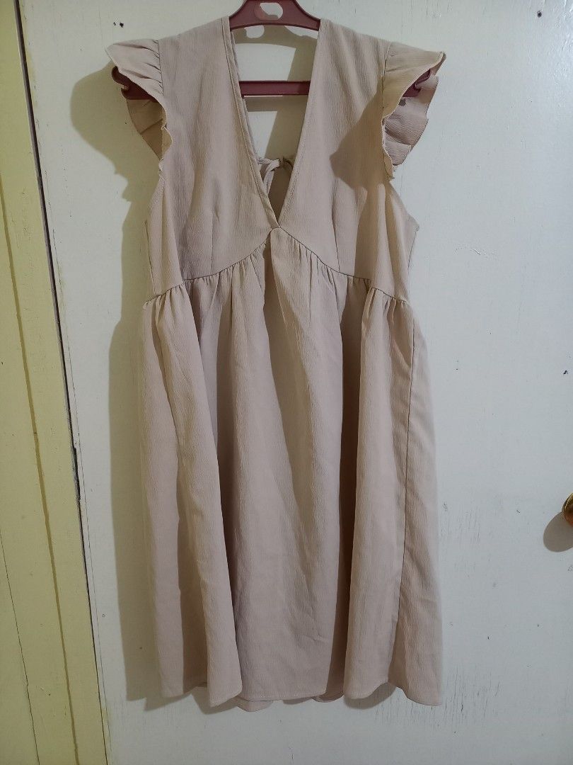 SHEIN Frenchy Solid Tie Back Smock Dress (Category: Dresses) located in Bulacan. Submitted by abscissa (Listing ID 1440685733, Image 2). Description: - Cute beige dress - Ruffle sleeves - V-neckline with criss-cross back detail - Elasticated waist - Flowy skirt - Ideal for casual outings - Easy to style with sandals or sneakers.