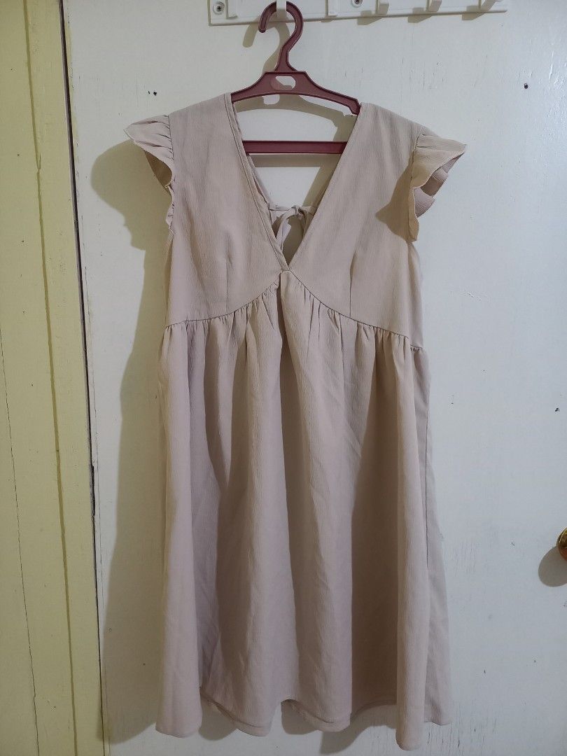 SHEIN Frenchy Solid Tie Back Smock Dress (Category: Dresses) located in Bulacan. Submitted by abscissa (Listing ID 1440685733, Image 1). Description: - Cute beige dress - Ruffle sleeves - V-neckline with criss-cross back detail - Elasticated waist - Flowy skirt - Ideal for casual outings - Easy to style with sandals or sneakers.