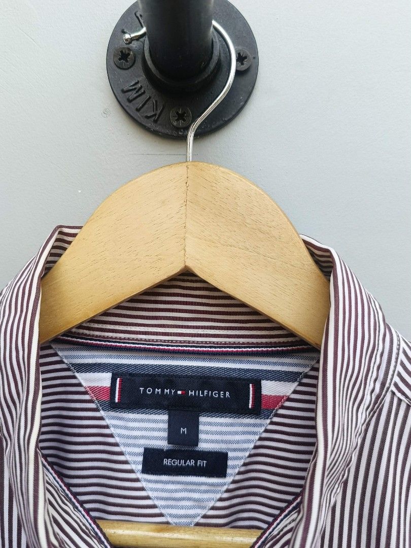 Tommy Hilfiger Men's Striped Button-Down Shirt - Size M (Category: Tshirts & Polo Shirts ) located in Taguig. Submitted by _theroom.ph (Listing ID 1440639996, Image 3). Description: - Brand: Tommy Hilfiger - Color: Burgundy and White Pinstripe - Style: Long-sleeved shirt - Material: 100% Cotton - Fit: Regular Fit - Features: Button-down collar, small embroidered logo on chest - Occasion: Casual or smart-casual wear.