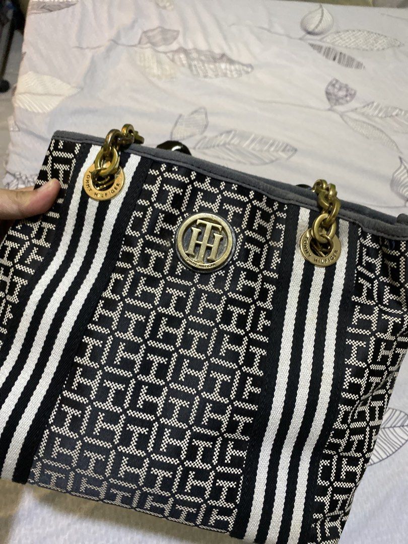 Tommy Hilfiger Monogram Tote Bag with Chain Straps (Category: Tote Bags) located in Bacoor. Submitted by arianne_domingo17 (Listing ID 1440748859, Image 2). Description: - Authentic Tommy Hilfiger tote bag - All-over TH monogram print - Black and white stripes on the sides - Gold chain and leather shoulder straps - Central Tommy Hilfiger logo hardware - Spacious interior - Ideal for everyday use - Has small stain at the back but not noticeable - 