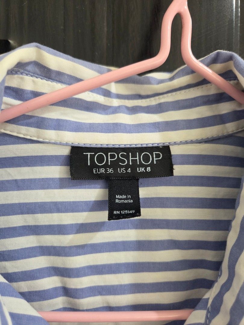 TOPSHOP Blue and White Striped Button-Down Shirt (Category: Shirts) located in Bacolod City. Submitted by maraline (Listing ID 1440673239, Image 2). Description: - Classic blue and white striped button-down shirt - Brand: TOPSHOP - Features a chest pocket - Button cuffs - Versatile for casual or smart-casual outfits - Made in Romania 079.