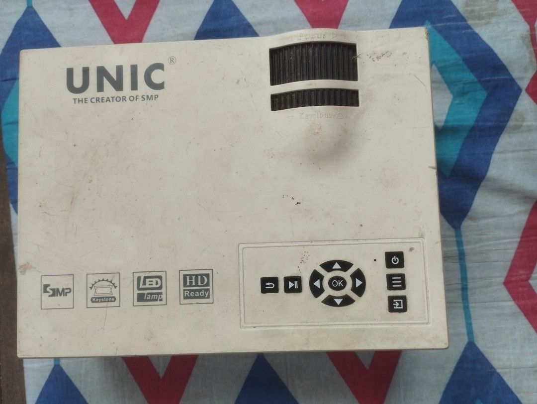 UNIC LED Projector (Category: Projectors) located in Manila. Submitted by clevercat-a177 (Listing ID 1440593518, Image 1). Description: - UNIC LED Projector - White color - HD Ready resolution - Top-mounted playback and navigation buttons - Front lens - Rear power input - Ideal for home entertainment.