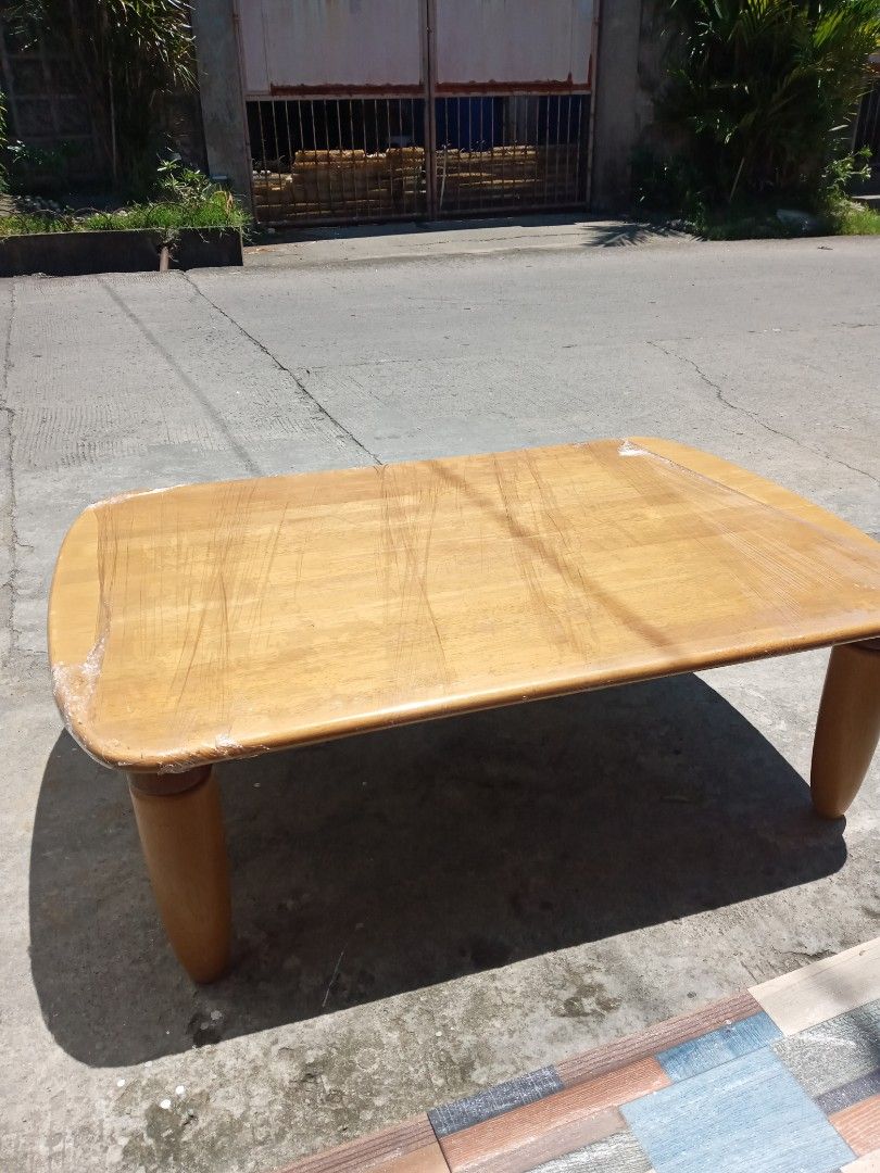 Wooden Coffee Table with Tapered Legs (Category: Tables & Sets) located in Manila. Submitted by mar.nel_1227 (Listing ID 1440754696, Image 1). Description: - Wooden coffee table with rounded edges - Features four tapered wooden legs - Surface has light scratches and wear, adding character - Underside is wrapped in plastic - Ideal for living rooms or lounge areas - Ready for its new home! 41"L x 27"W x 13"H.
