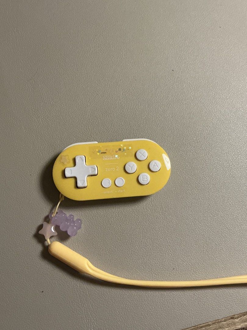 8Bitdo Zero 2 Mini Bluetooth Gamepadyellow (Category: Controllers) located in San Fernando. Submitted by beashopacc (Listing ID 1435785492, Image 1). Description: - 8BitDo Zero 2 Bluetooth gamepad (Yellow) - Compact and portable - Features a D-pad and face buttons - Includes a wrist strap with decorative beads - Used about 5 times only for studying.