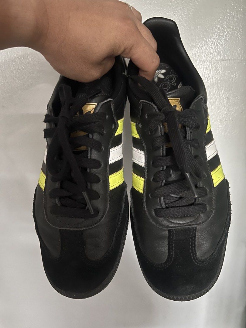 Adidas Samba Black Yellow Sneakers (Category: Sneakers) located in Quezon City. Submitted by Maria.Sierra (Listing ID 1435809586, Image 3). Description: - Adidas Samba sneakers - Black colorway with yellow and white stripes - Features black sole and laces - "SAMBA" text visible on the side - Adidas logo on the tongue - Minimal wear on soles.