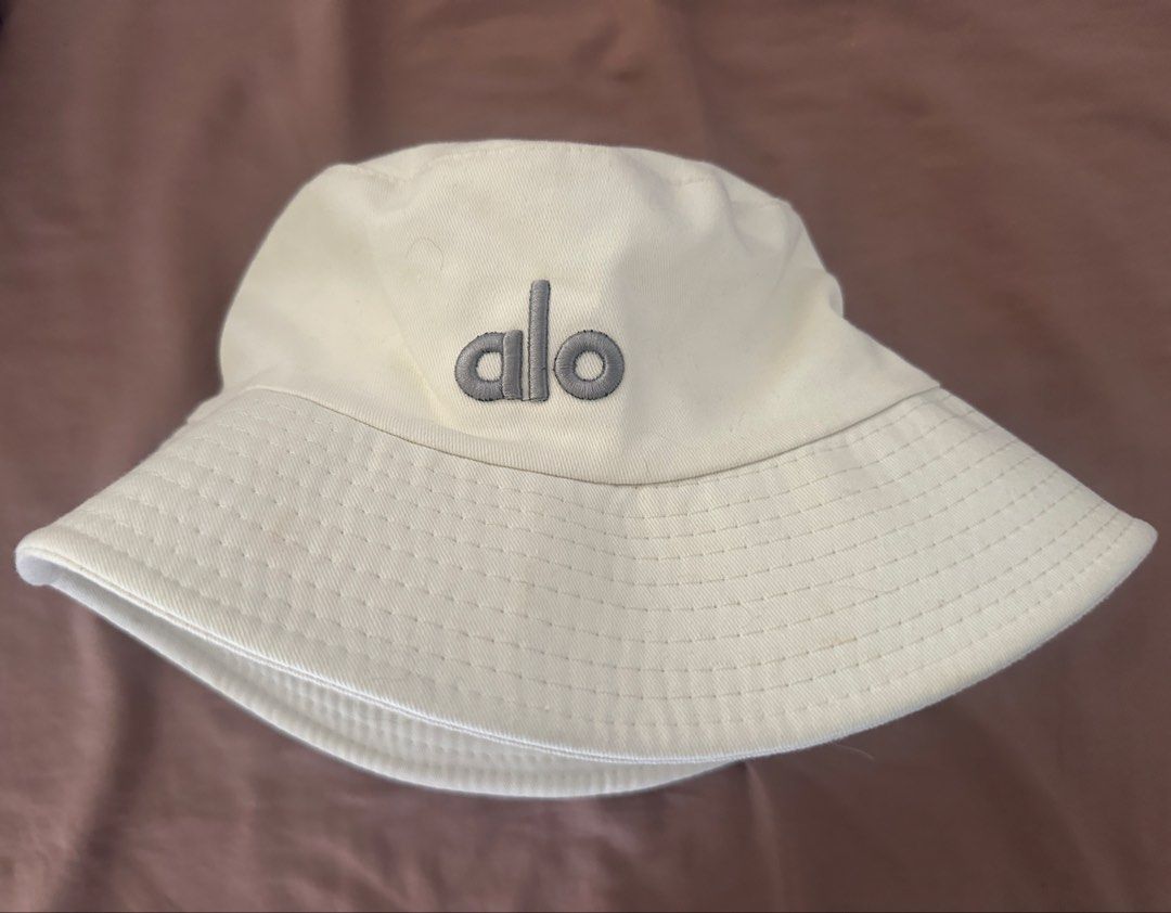 ALO YOGA Weekender Bucket Hat (Category: Hats & Beanies) located in Manila. Submitted by manifestd (Listing ID 1435767119, Image 1). Description: ALO YOGA Weekender Bucket Hat ✔️Cream, never worn (not my style, given as a gift, rfs: decluttering) ✔️Unisex, free size, classic bucket hat design ✔️Embroidered ALO logo ✔️Lalamove/J&T ready.