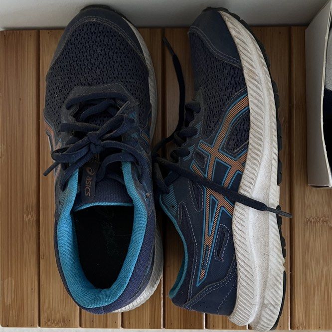 Asics Gel-Contend 4 Running Shoes - EU 37 (Category: Sneakers) located in Singapore. Submitted by eleventhnovember (Listing ID 1435770855, Image 2). Description: - Used Asics Gel-Contend 4 running shoes - Navy blue with light blue and orange accents - Size: EU 37, UK 4.5 - Signs of wear on soles and uppers - Made in Vietnam - Suitable for casual wear or light exercise.