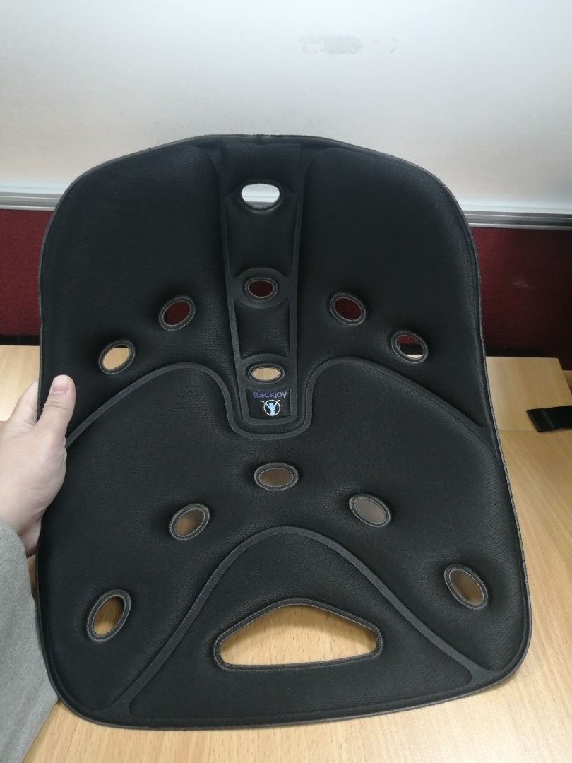 Backjoy Posture Support (Category: Braces, Support & Protection) located in Makati City. Submitted by realsnapshoppe (Listing ID 1435735019, Image 3). Description: - Backjoy posture support in black. - Designed to improve posture while sitting. - Features a contoured design. - Multiple holes for ventilation. - Textured underside. - Includes instructions for use. - Backjoy logo visible. - Includes a sticker with a QR code..