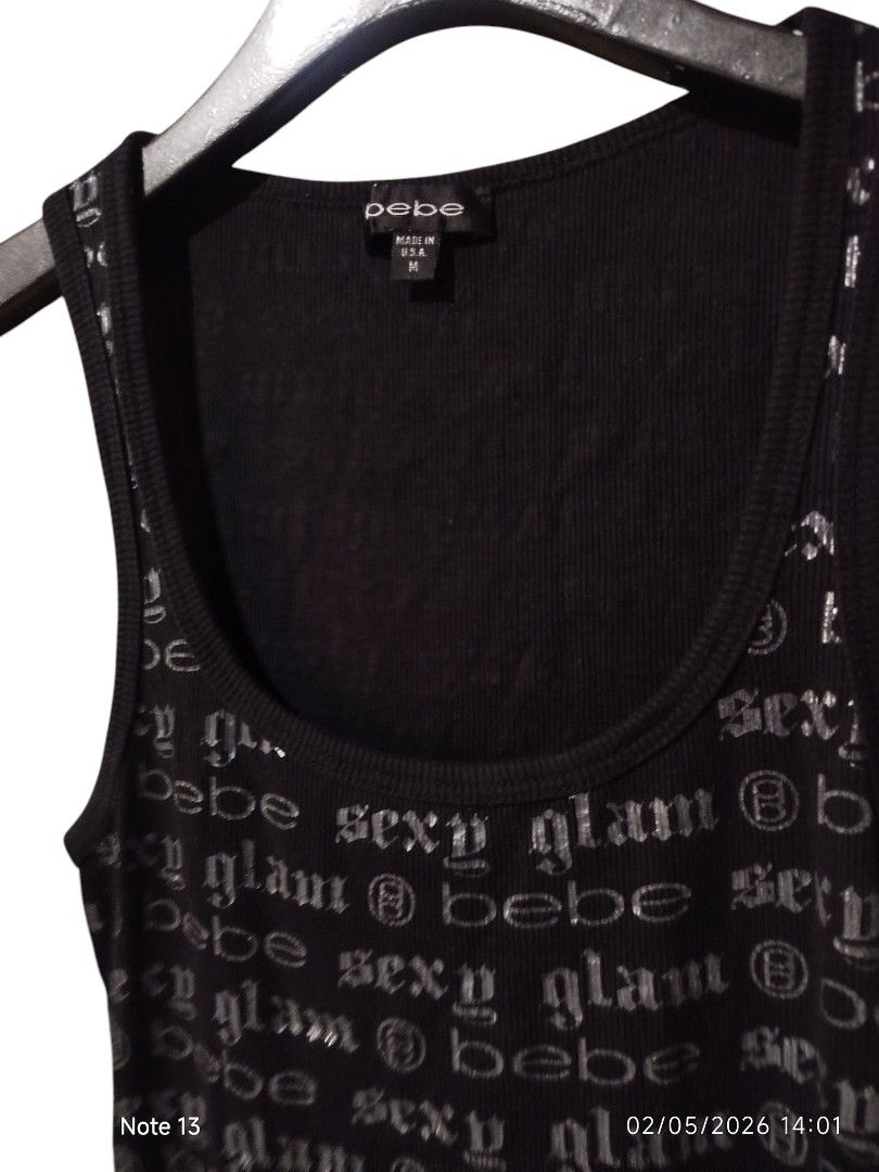 Bebe Tank Top All Over Print (Category: Sleeveless) located in San Juan (Cabalian). Submitted by ec8thrift (Listing ID 1435723228, Image 2). Description: - Bebe black tank top - Features scoop neck - 'Sexy glam @ bebe' text - Size M - Ribbed texture - Made in USA - Fabric: 93% cotton, 7% spandex.