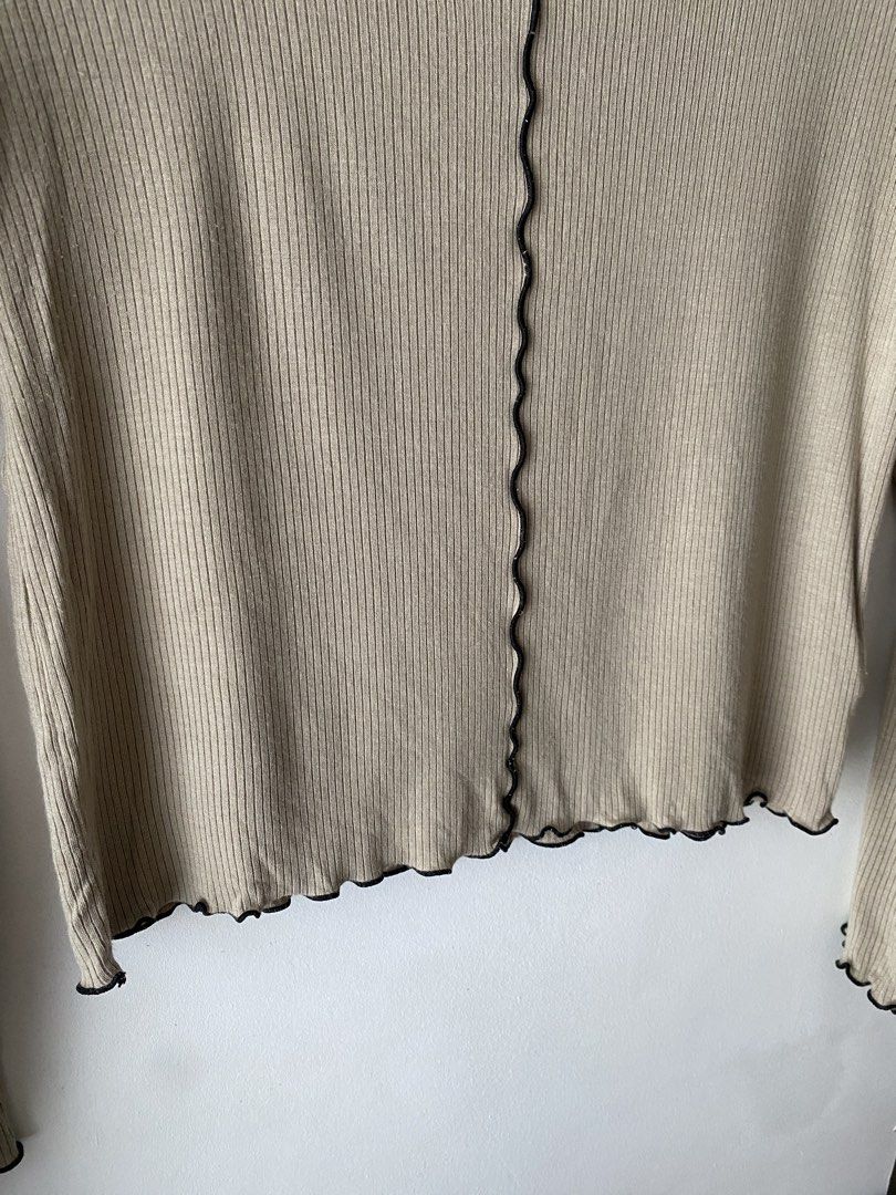 Beige Long Sleeve Top with Black Trim (Category: Longsleeves) located in Makati City. Submitted by kxthr (Listing ID 1435740751, Image 3). Description: - Beige long-sleeved top - Black wavy trim on neckline, hem, and sleeves - Ribbed texture - Decorative black seam down the center - Scoop neckline - Lightweight material - Perfect for layering - Versatile style.