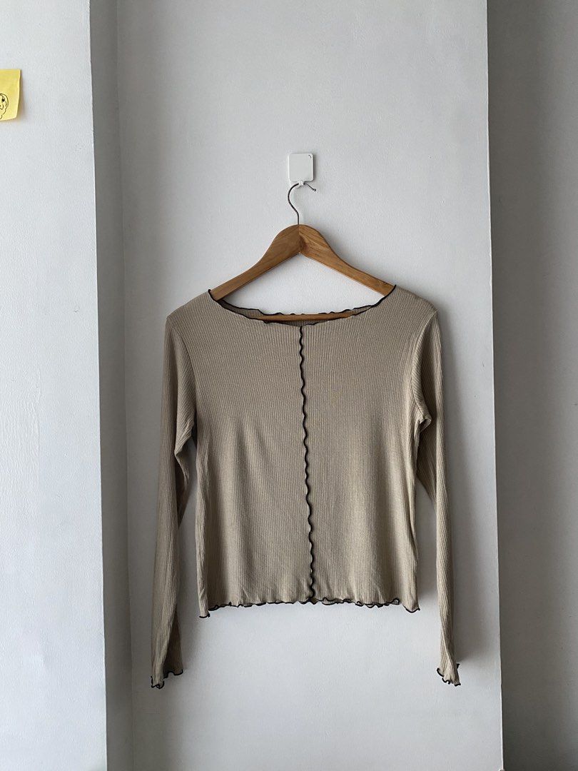 Beige Long Sleeve Top with Black Trim (Category: Longsleeves) located in Makati City. Submitted by kxthr (Listing ID 1435740751, Image 2). Description: - Beige long-sleeved top - Black wavy trim on neckline, hem, and sleeves - Ribbed texture - Decorative black seam down the center - Scoop neckline - Lightweight material - Perfect for layering - Versatile style.