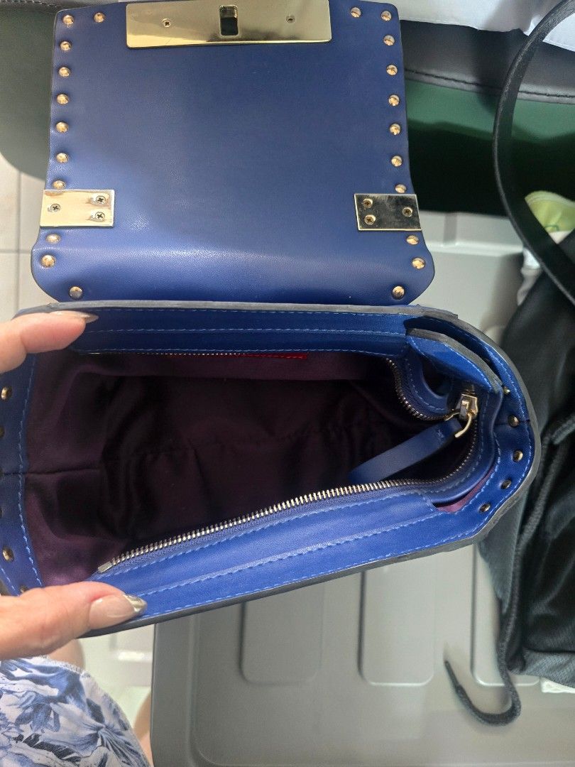 Blue Studded Handbag (Category: Luxury Bags & Wallets) located in Valenzuela. Submitted by lzl2428 (Listing ID 1435791274, Image 3). Description: Stylish blue handbag with gold-colored studs and hardware. Features a flap closure with a gold clasp. Includes a shoulder strap with matching studs. The interior has a zippered pocket..